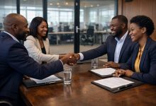 business teams shaking hands after signing a contract in a corporate boardroom
