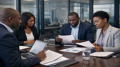 Business professionals reviewing supplier documents and contracts during a procurement meeting in a modern office boardroom